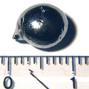 一张小小的rhenium颗粒的照片，旁边是标尺的标尺。