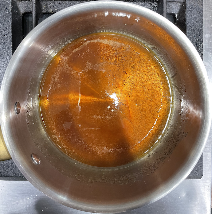 一一底部焦糖蔗糖的钢锅的照片