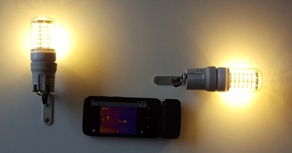 用于验证LED灯泡模型的实验设置的照片，其中两个LED灯泡打开，中间有一个红外摄像头。