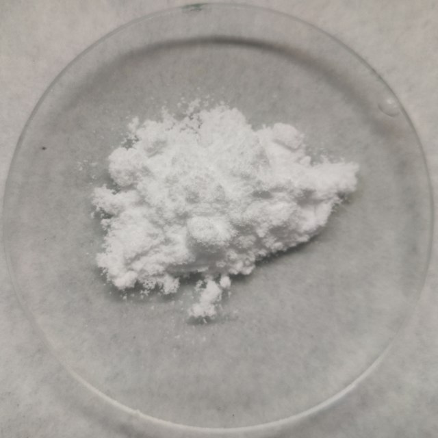 白色粉末形式的三聚氰胺聚集在透明板上。